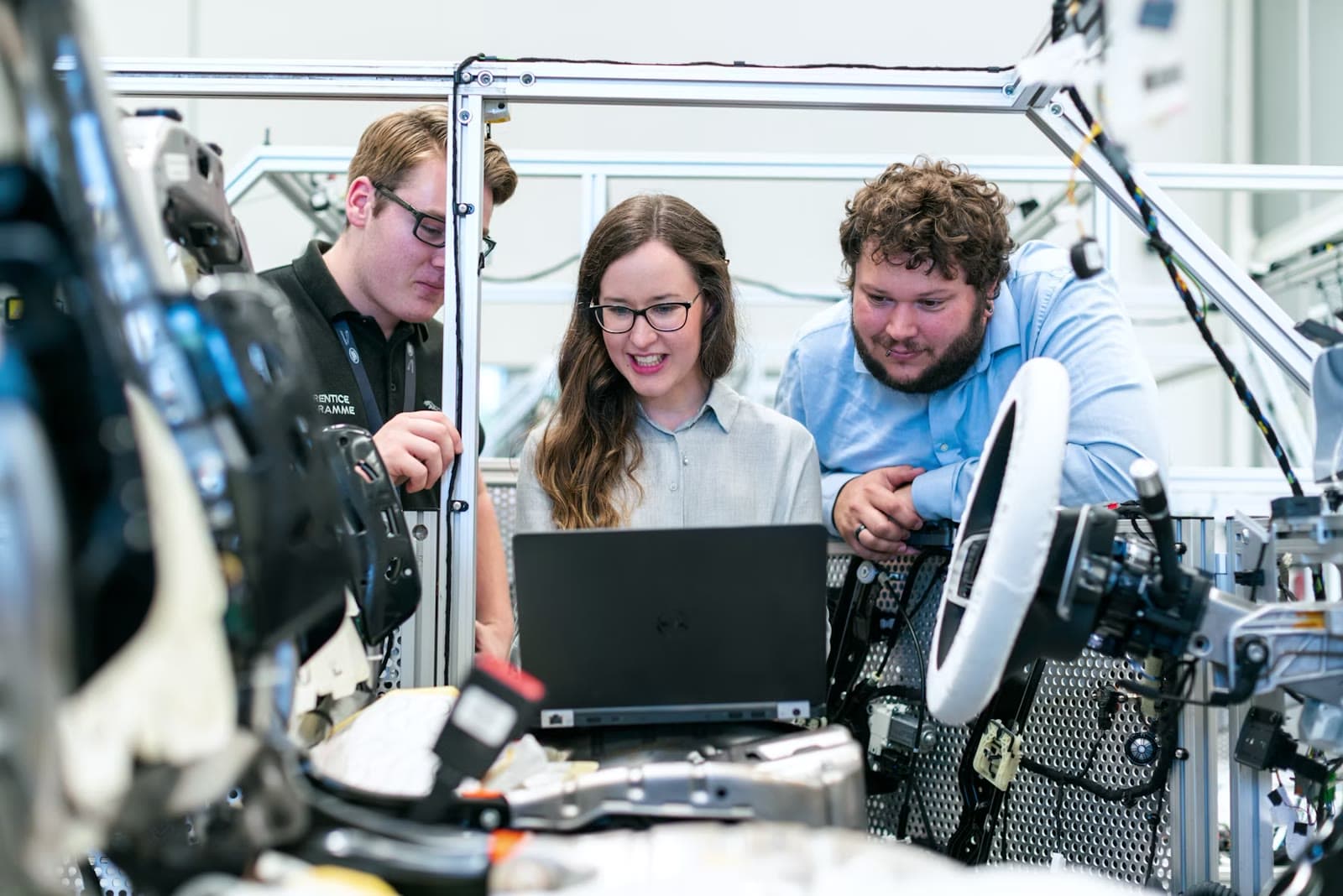 Industrial engineering team reviewing work together around a laptop